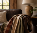 Hudson Valley Plaid woven cotton throw blanket draped over sofa arm showing natural drape and plaid construction, warm earth tone interior
