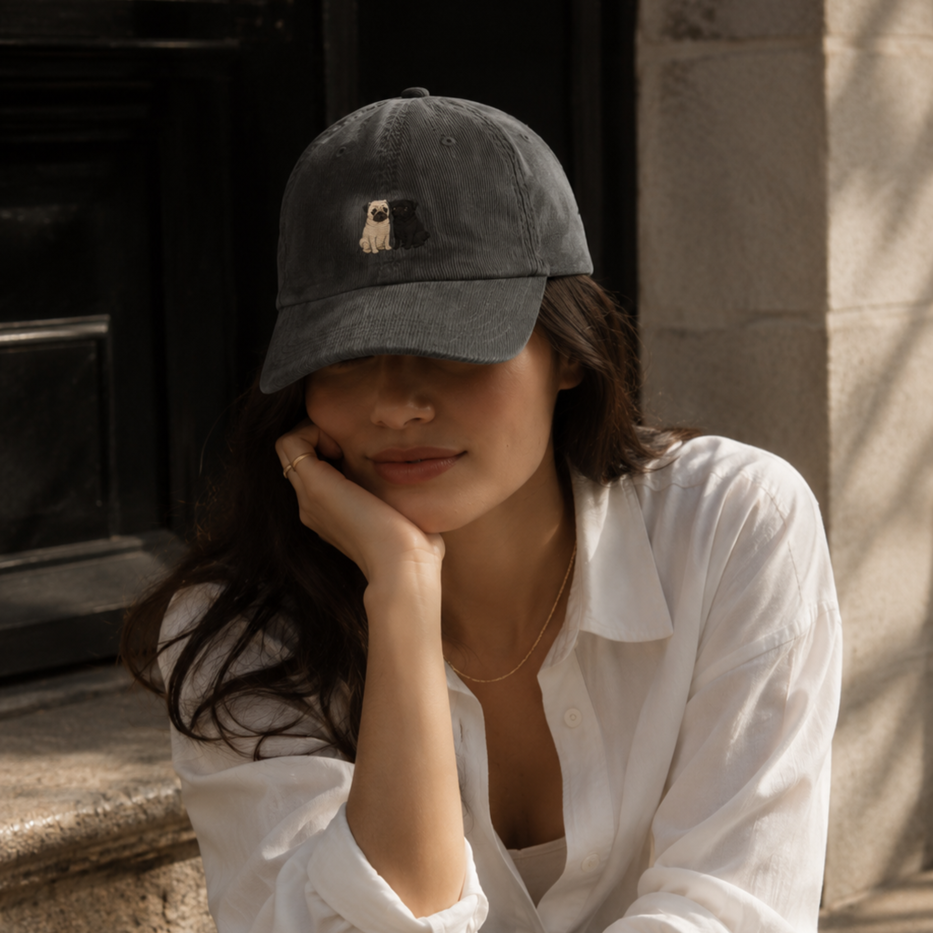 Woman wearing grey pug duo embroidered corduroy hat at golden hour in garden — pug mom hat by Trini Skies