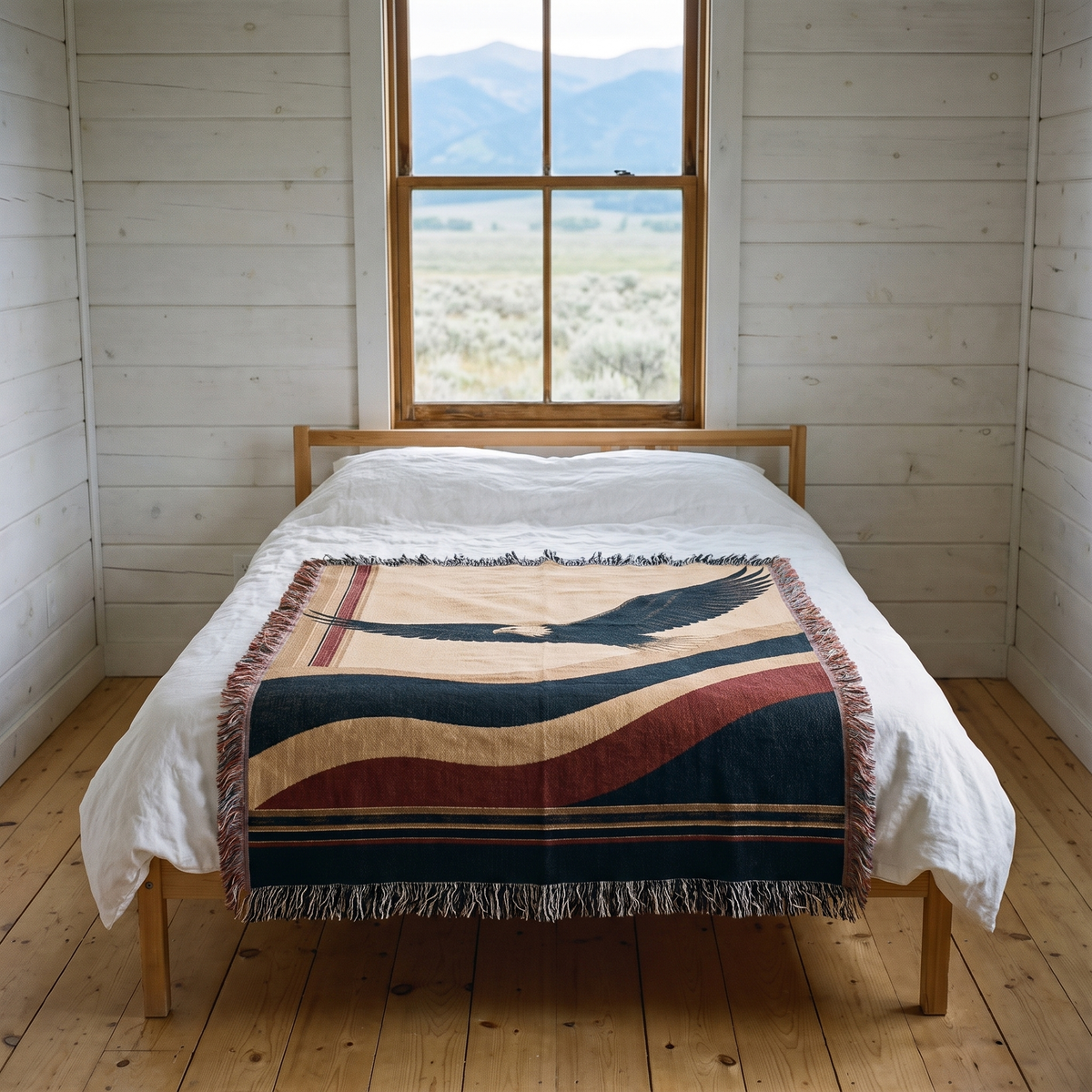 American eagle woven cotton throw across a white linen bed in a Montana ranch bedroom with a mountain window