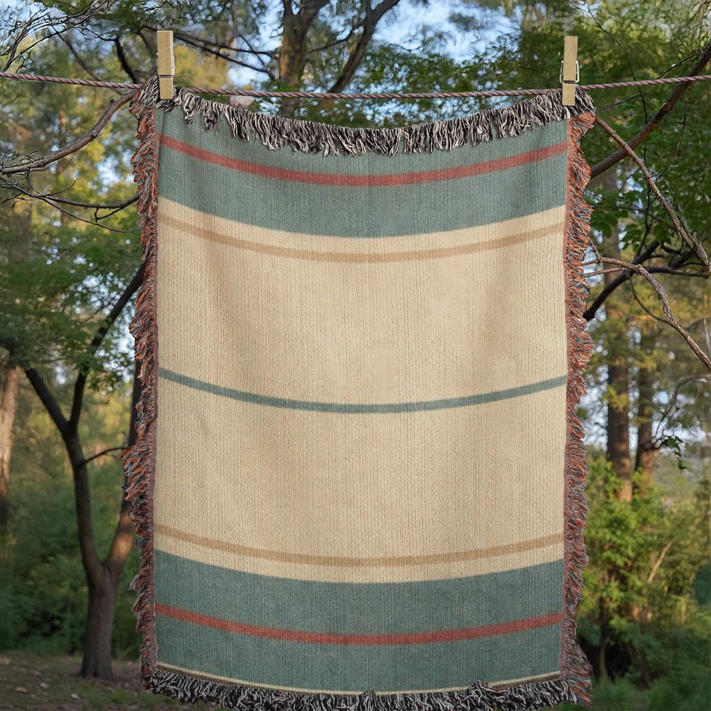 Woman sitting on a beach spread with The Shorewood coastal blue heritage stripe woven cotton throw blanket, reading a book — Trini Skies