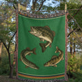 Woven mockup of The Lake Country design showing the bass mid-strike, coiled pike, and gliding walleye on a vibrant forest green field with heritage stripe border, before final rendering — Trini Skies