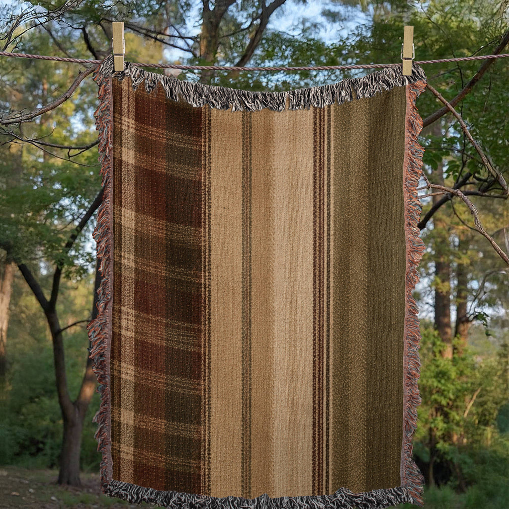 Woman draped in Hudson Valley Plaid woven cotton throw blanket standing in forest setting, plaid pattern in earth tones with multicolor fringe