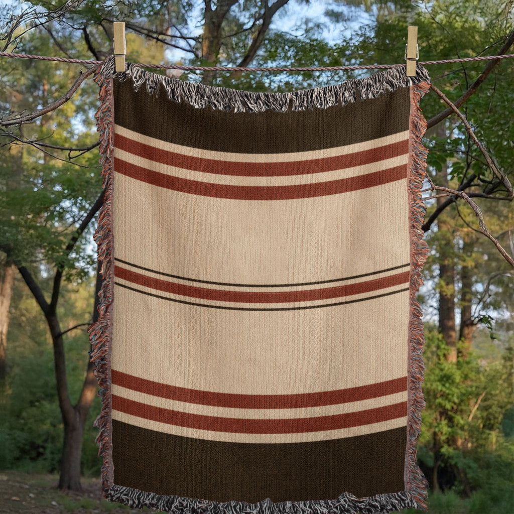 The Canyon woven cotton throw blanket shown full, espresso brown and warm ivory heritage stripe with barn-red accent bands — Trini Skies