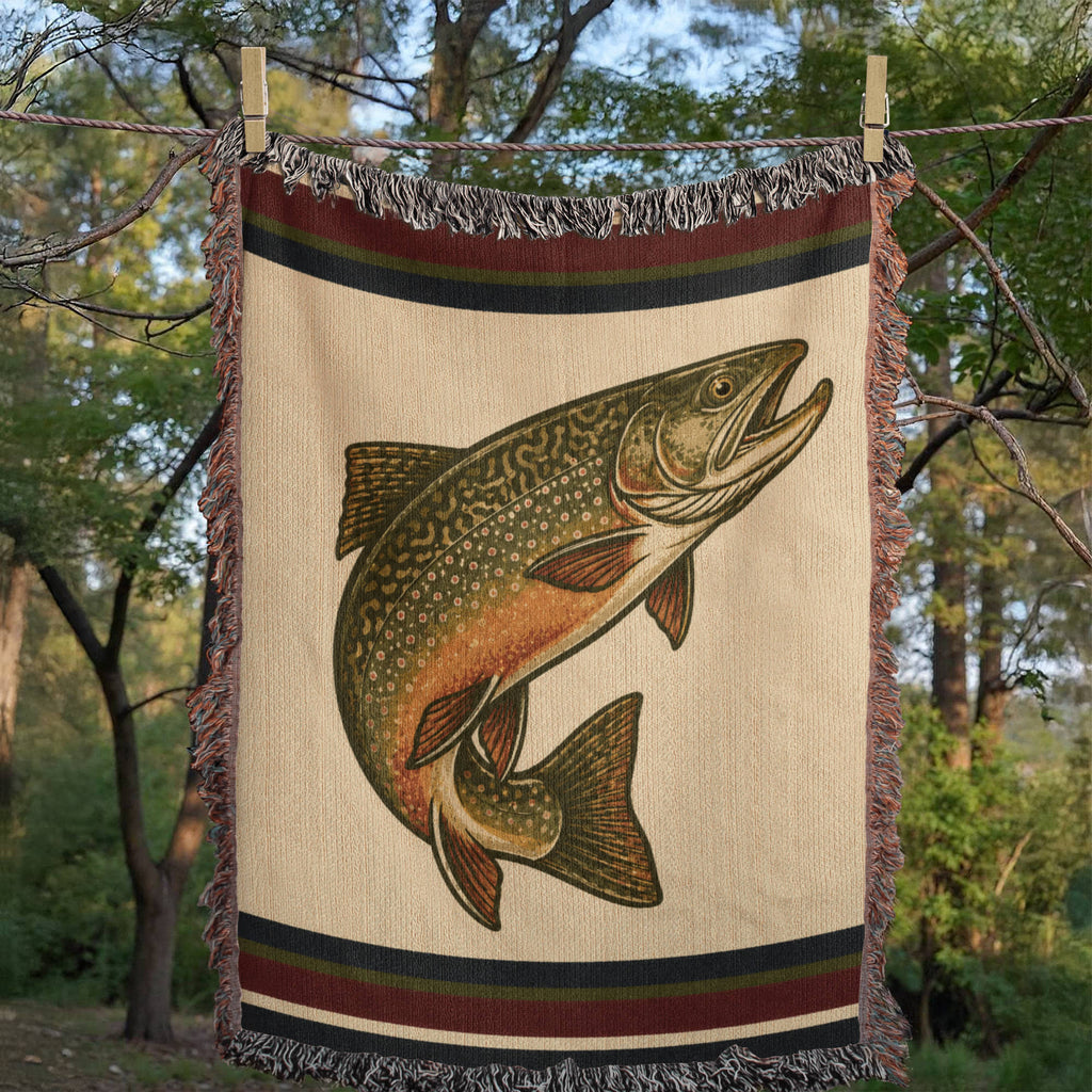 Woven mockup of The Freestone brook trout design showing the heritage stripe border and jacquard trout illustration on an ivory field — Trini Skies