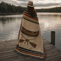 The Portage canoe woven throw wrapped around a woman on a lake dock at dusk — Trini Skies
