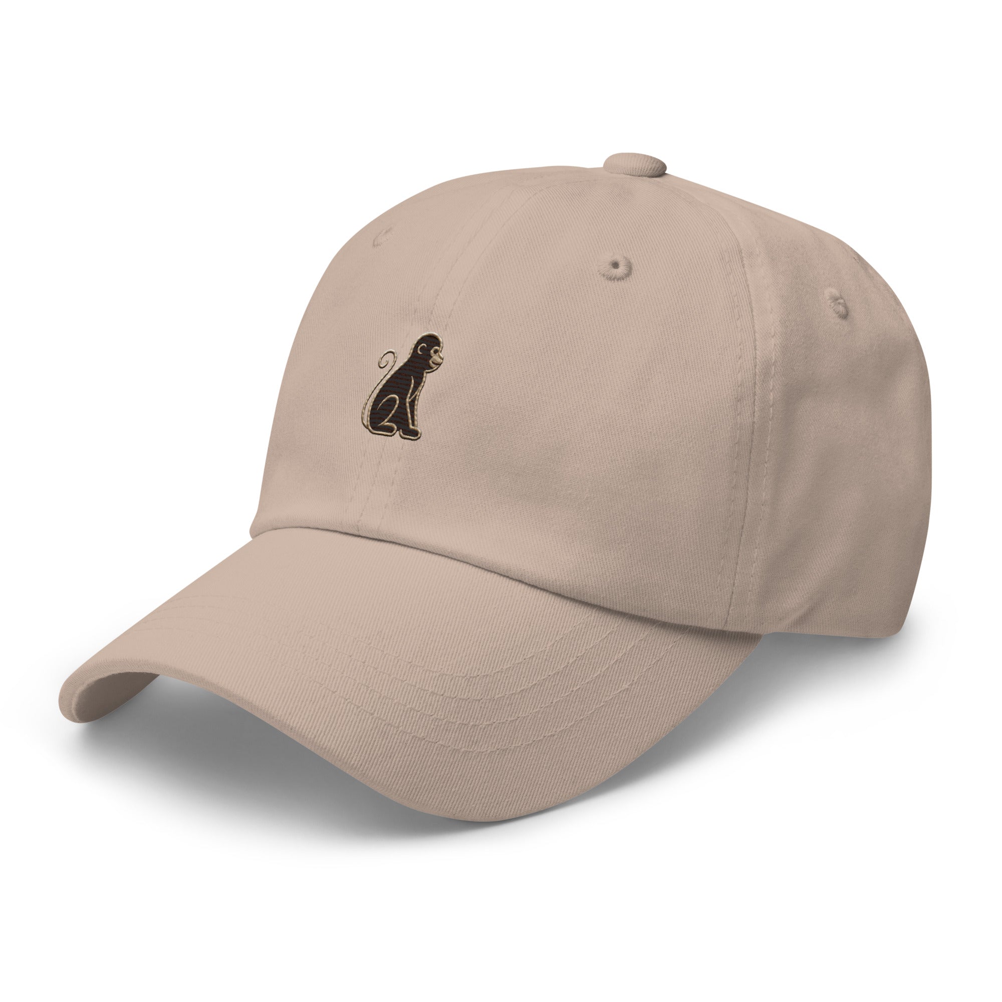 Signature Monkey Embroidered Dad Hat by Trini Skies in stone cotton twill, left front view showing monkey emblem embroidery, unstructured low-profile crown