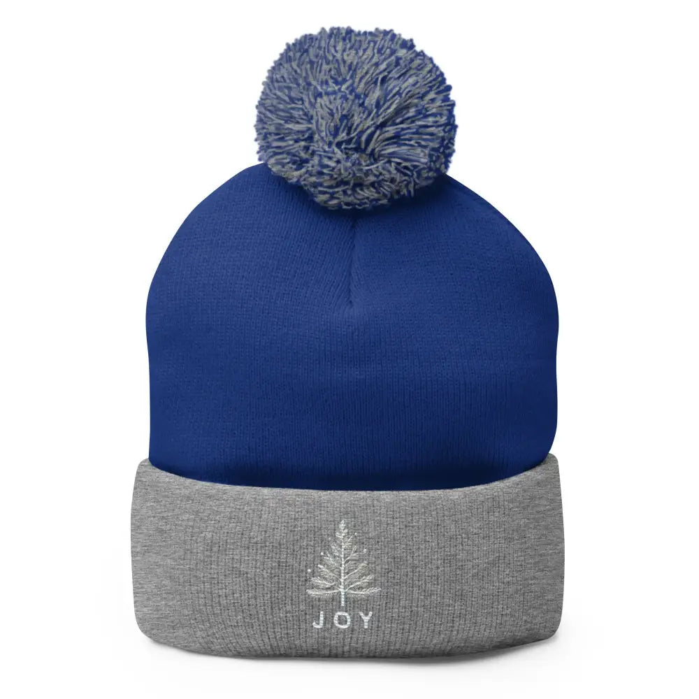 Embroidered Joy Christmas pom-pom beanie in blue and grey with tree design