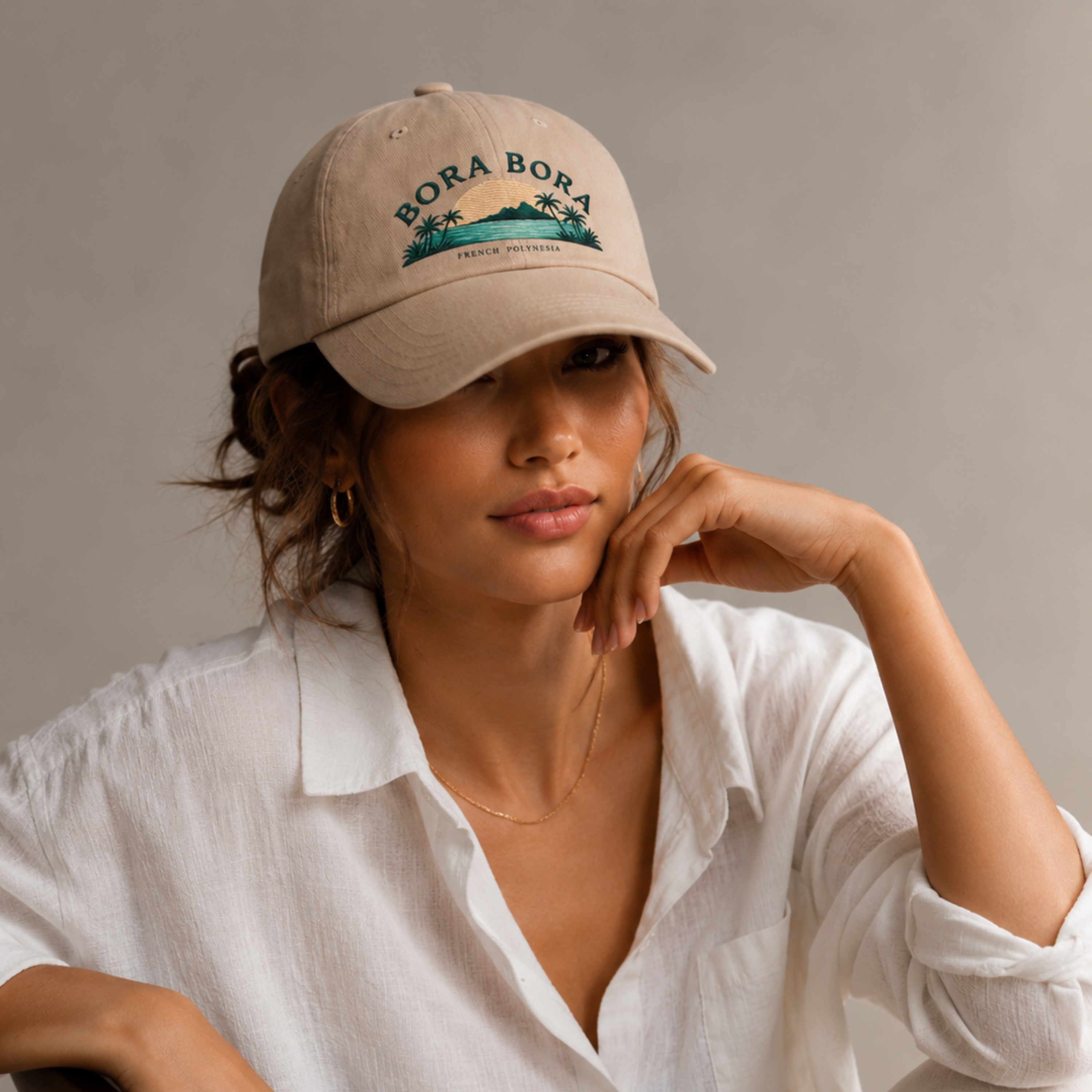 Woman wearing a beige cap with 'Bora Bora' text and palm tree design on a neutral background