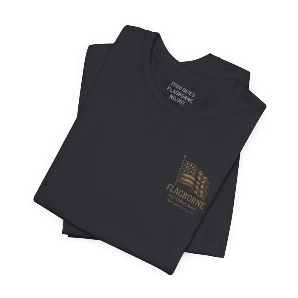 Folded black Trini Skies Supply tee with distressed American flag graphic