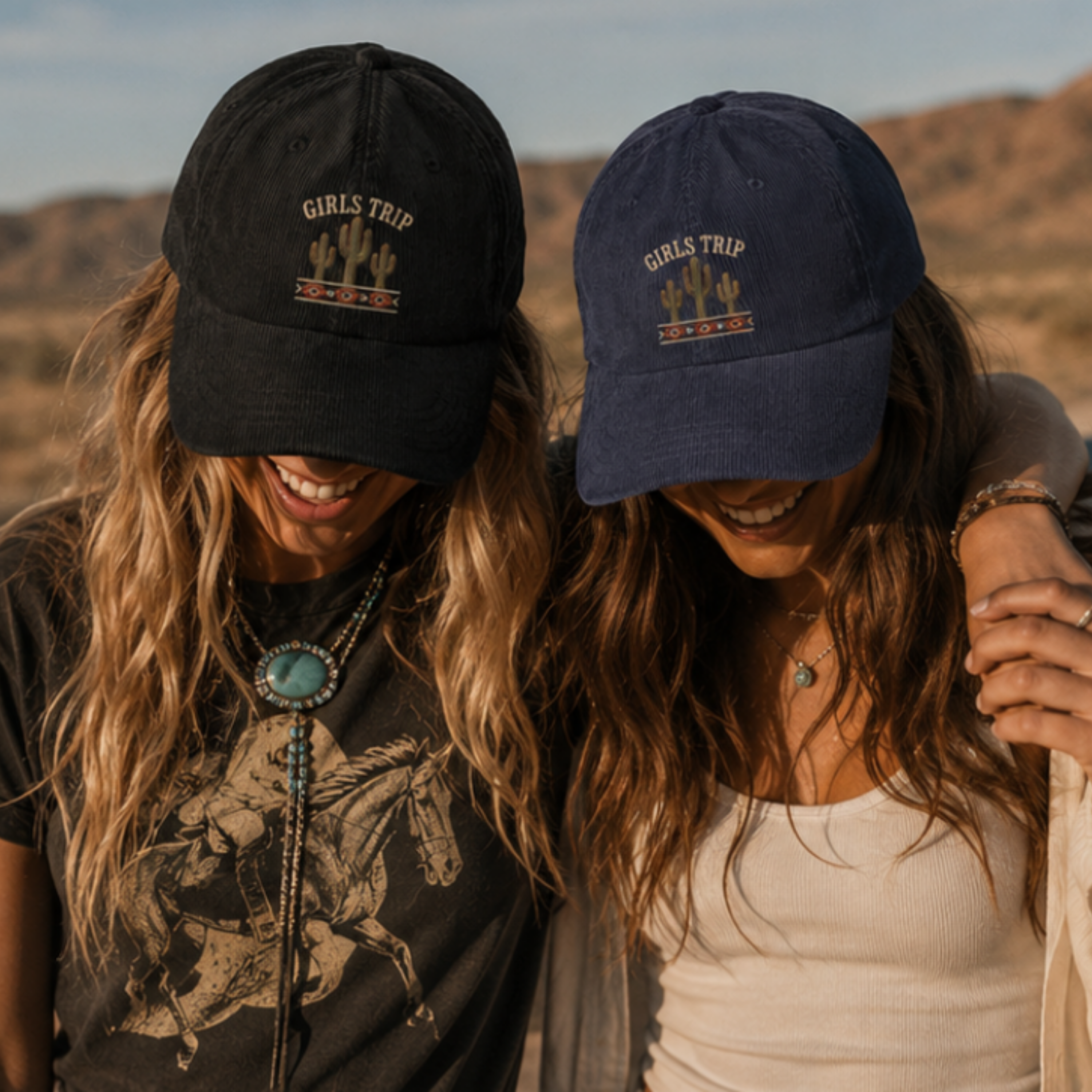 Two women wearing 'Girls Trip' hats in a desert setting
