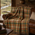 The Drifter heritage plaid woven throw draped over a leather sofa in a riverside cabin — Trini Skies