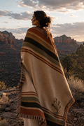 Woman wrapped in Joshua Tree woven throw blanket on desert rock outcrop at golden hour with canyon backdrop — southwestern blanket by Trini Skies