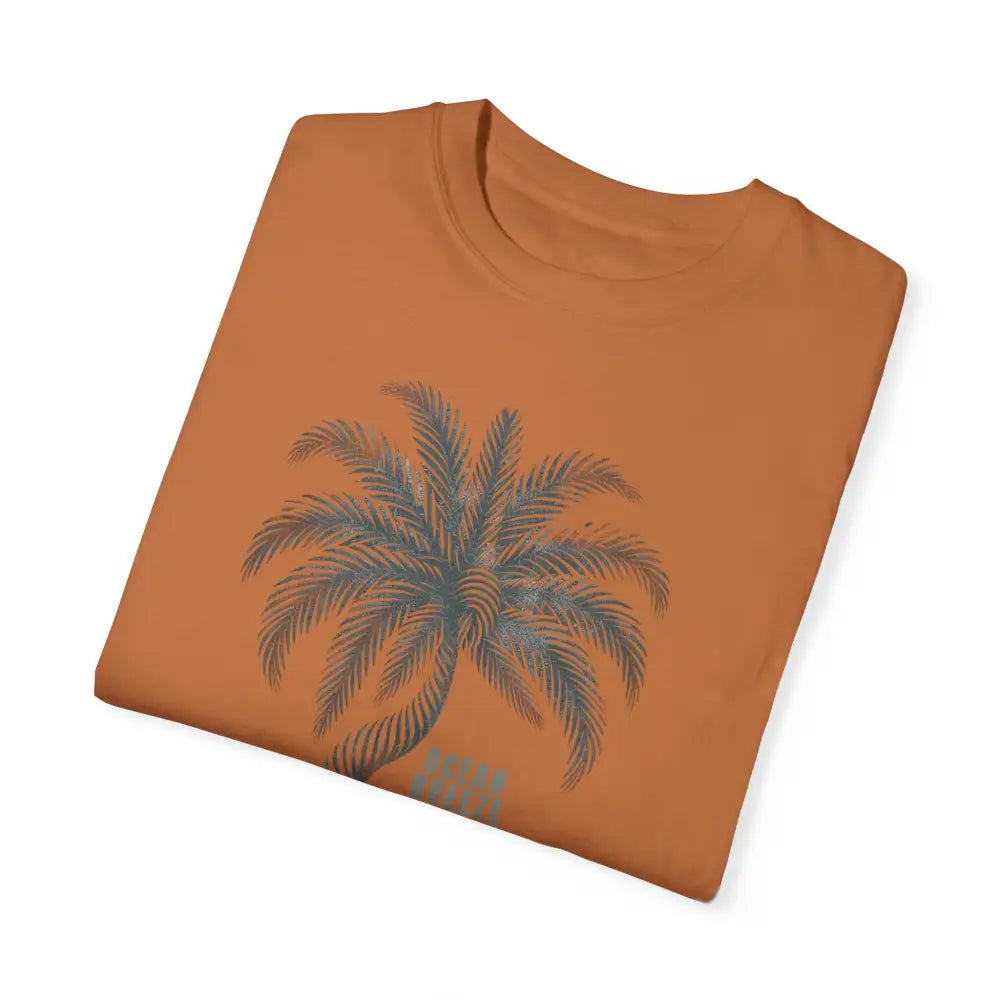 Folded rust-orange ring-spun cotton t-shirt with dark grey palm tree graphic