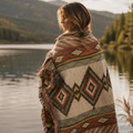 Desert Mesa Southwestern woven blanket in rust, clay, and sage layered at the foot of a bed in a mountain lodge setting outdoors — Trini Skies
