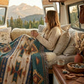 Spruce Mesa Southwestern woven throw blanket around the shoulders in a camper van with a mountain view — Trini Skies