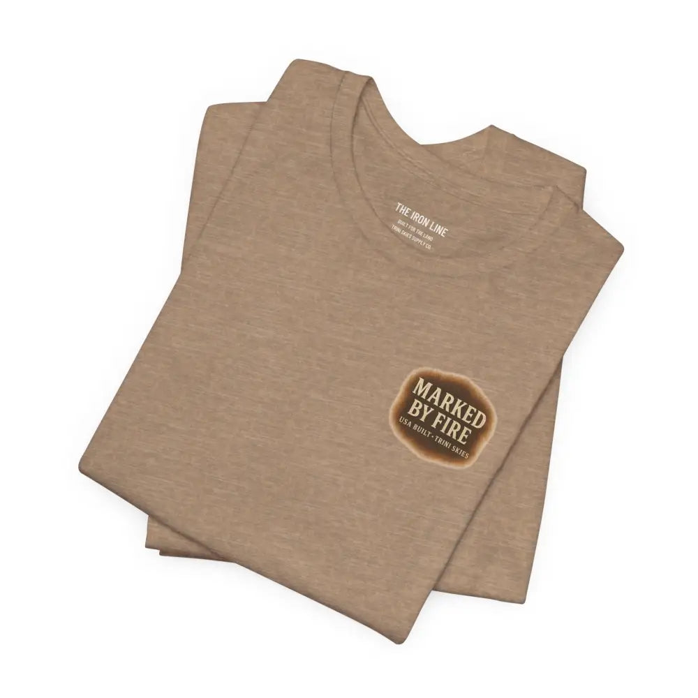 Folded tan Trini Skies Supply graphic tee with Marked by Fire design