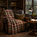 The Hearthstone red and green plaid woven throw draped over a leather chair in a cabin library — Trini Skies
