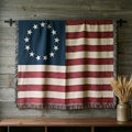 Betsy Ross 13-star flag woven cotton throw hung on a barnwood wall above a walnut console with dried wheat