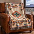 Rust and navy geometric medallion woven cotton throw blanket draped over a leather armchair