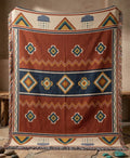Storm Front rust and navy geometric woven cotton throw blanket with fringe on a rocky mountain ledge