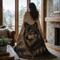 Woman wrapped in Sentinel of the North wolf portrait woven tapestry throw blanket standing on a dock at golden hour with mountain lake behind her